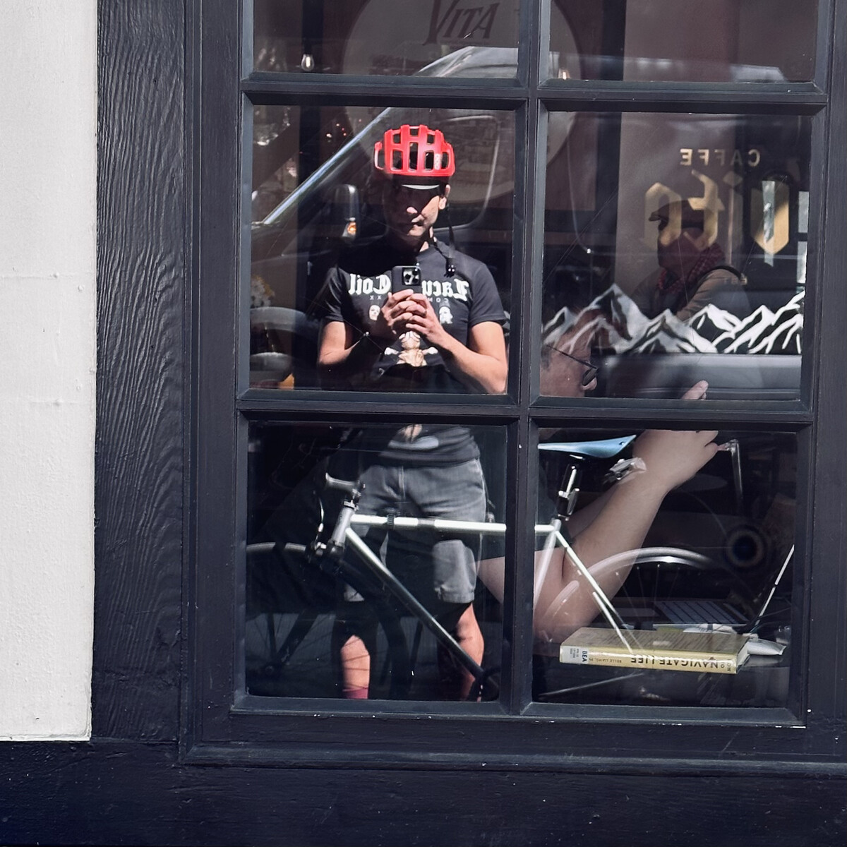 Photo of me and my bike reflected in a window.